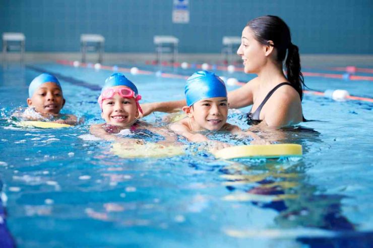 Bambini in piscina con insegnante