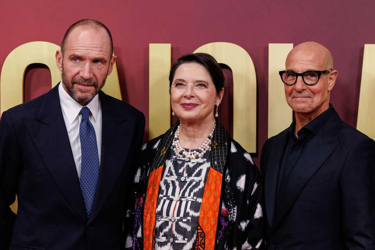 Ralph Fiennes isabella Rossellini e Stanley Tucci con alle spalle la scritta Conclave