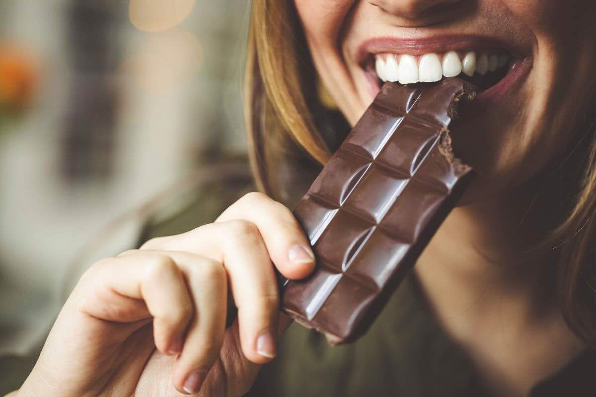 Donna mangia cioccolato fondente