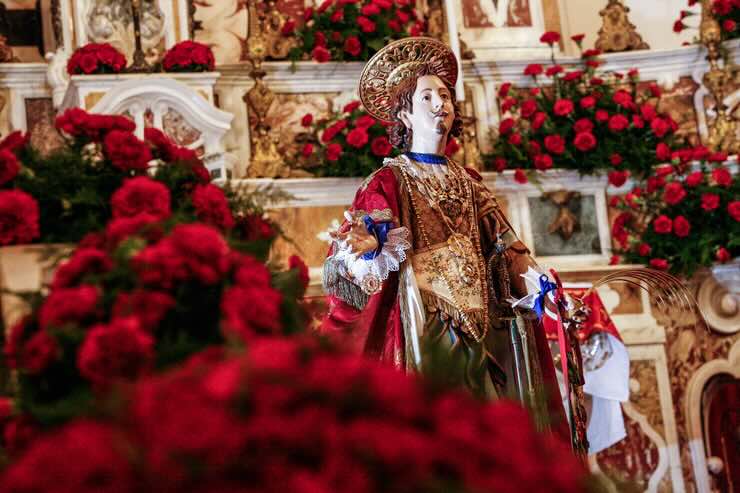 Statua di Sant'Efisio con rose rosse attorno 