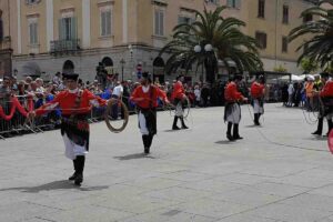 Uomini vestiti con abiti tipici sardi in mezzo alla piazza