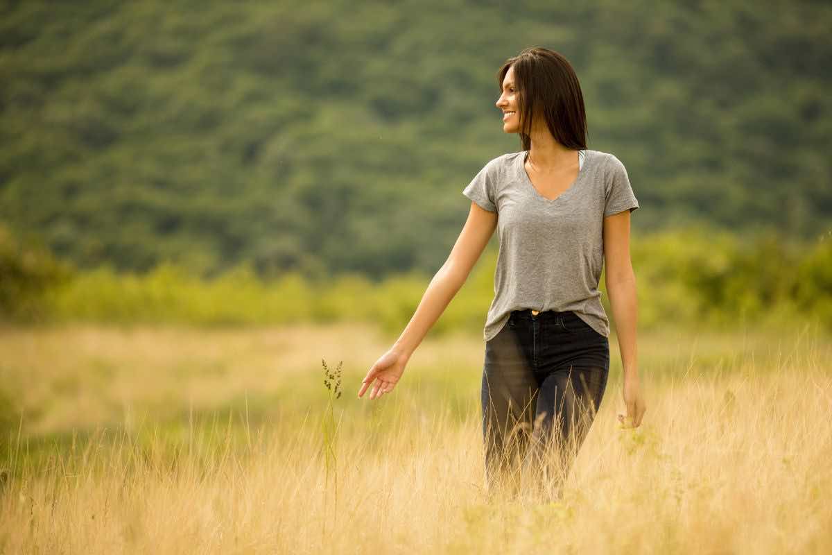 Donna che passeggia nell'erba alta 