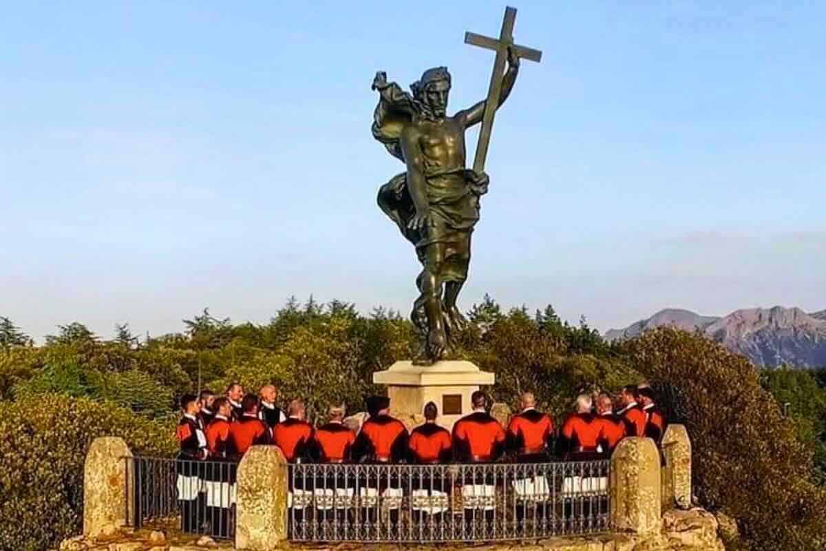 Statua del Redentore a Nuoro con fedeli vestiti dell'abito tradizionale