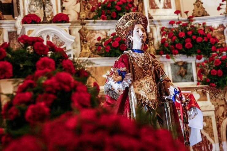 Statua di Sant'Efisio con rose rosse intorno 