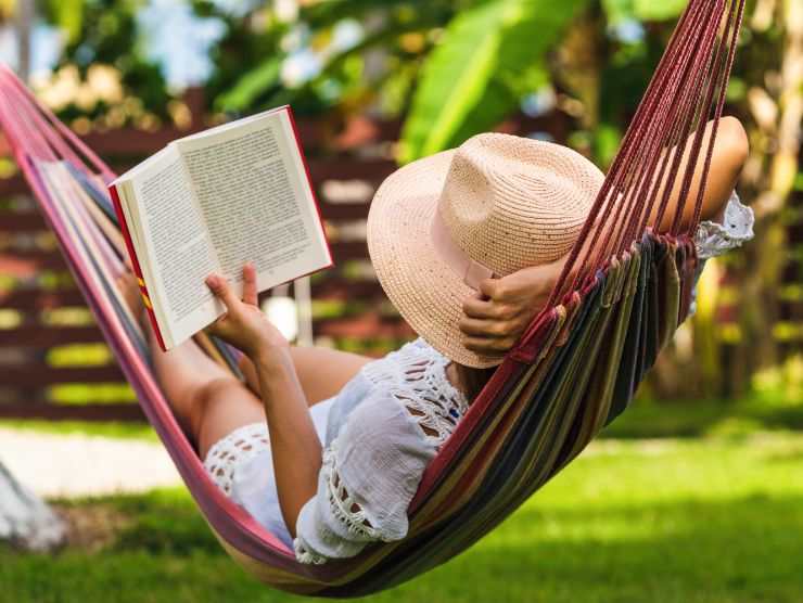 donna su un'amaca che legge un libro