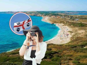 bandiera della Sardegna, donna che fotografa e insenatura come sfondo